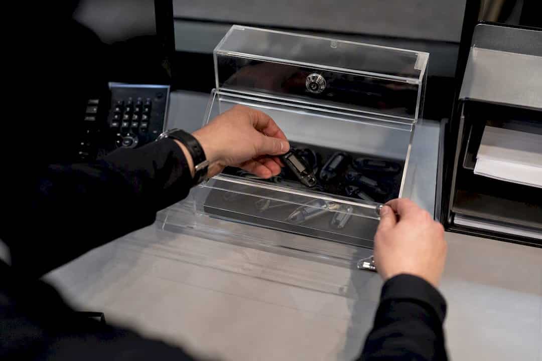 Hands handling digital authentication token and evidence box